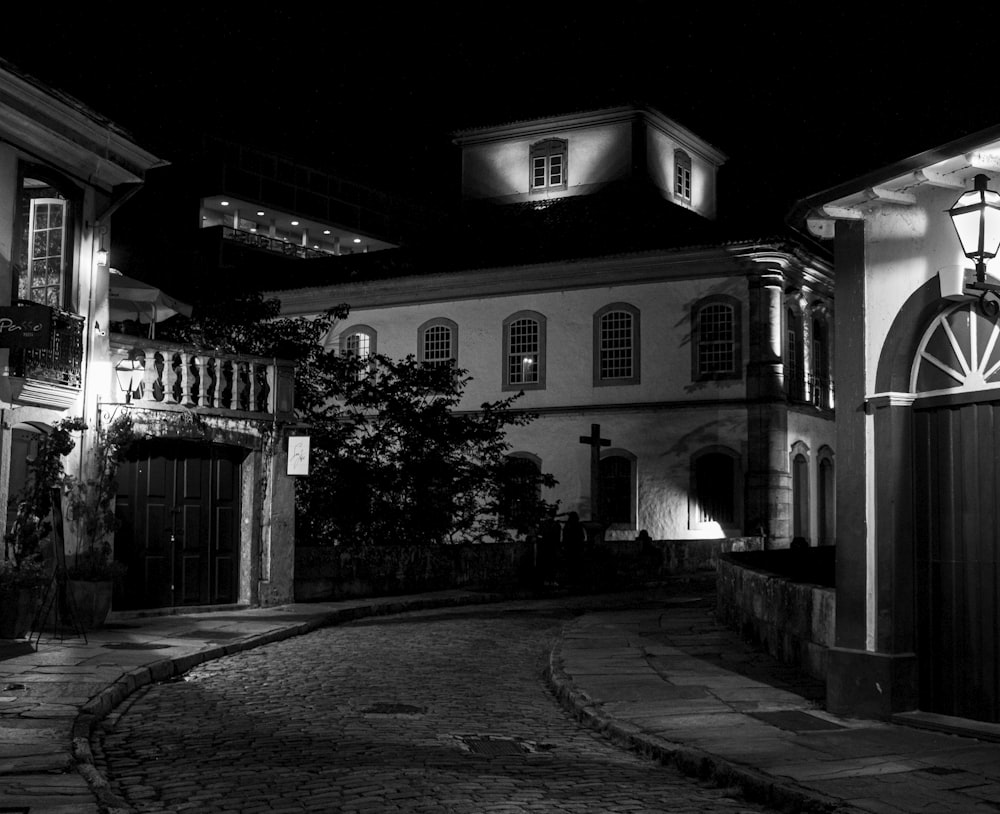 a black and white photo of a street at night