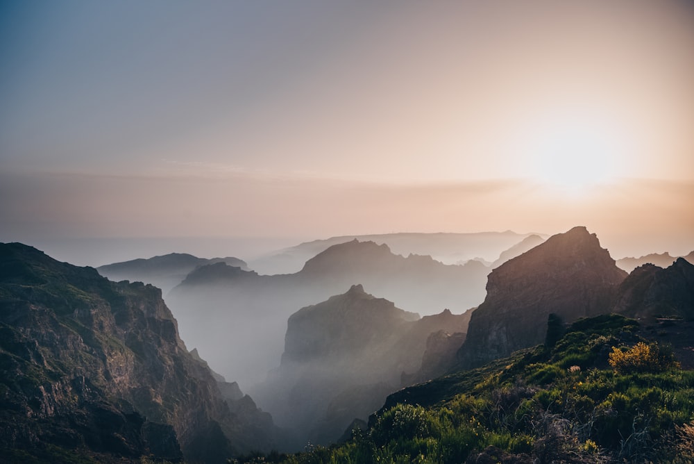 the sun is setting over a mountain range