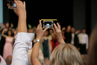 Audience members capturing moments with their smartphones at a live event
