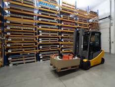 a forklift with a box on it in a warehouse