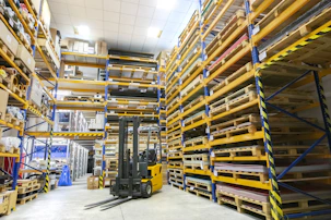 Smiling staff organizing assorted products on shelves in a bright and orderly warehouse.