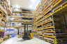 A neatly organized warehouse aisle filled with labeled shelves of various auto parts ready for shipment.