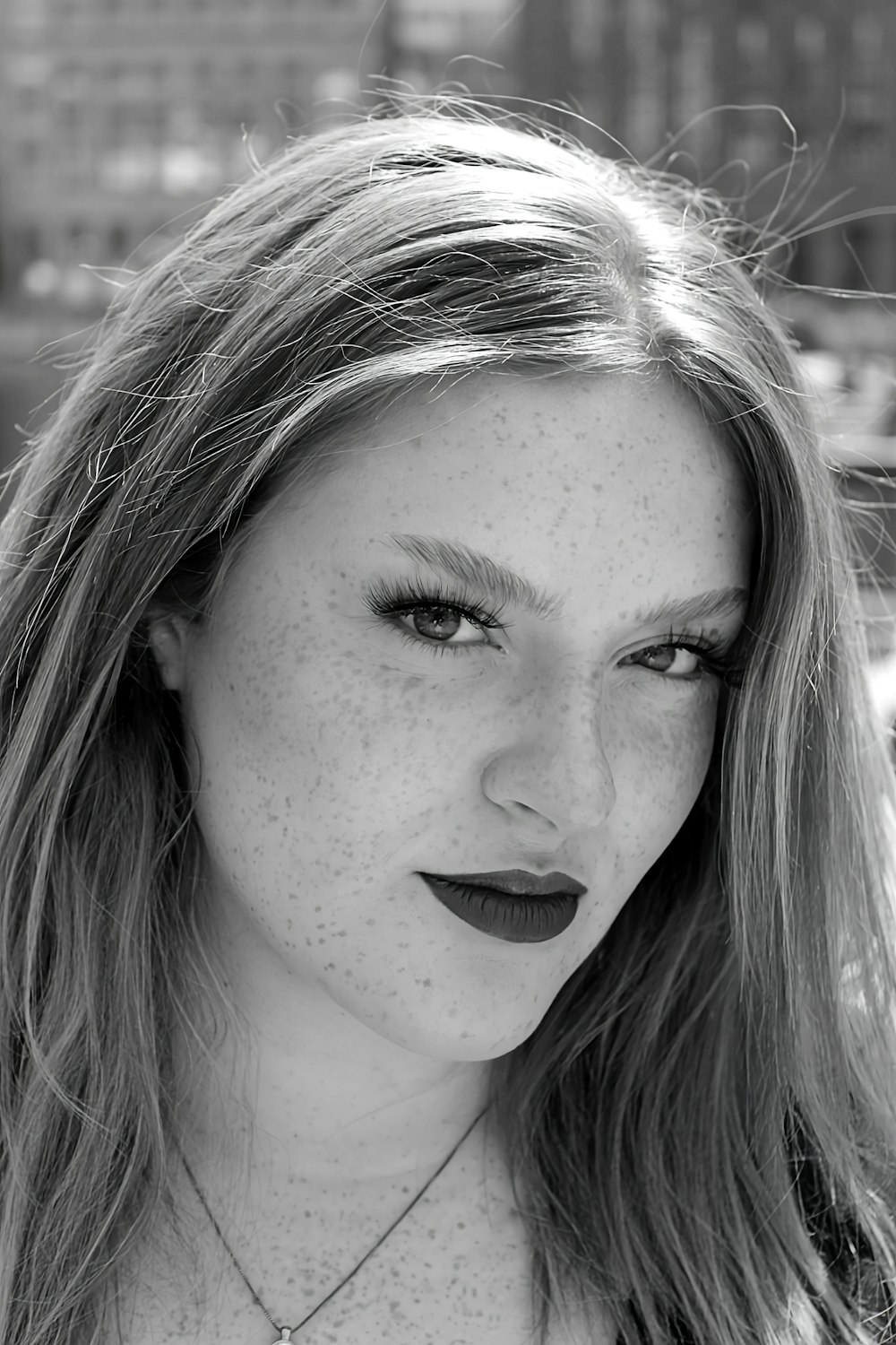 a black and white photo of a woman with freckled hair