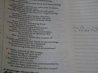 A page from a book is shown, with printed text on the left side. The text appears to be poetic or biblical in nature. To the right, there is a section with lined paper featuring handwritten notes, including a reference to a verse or page number.