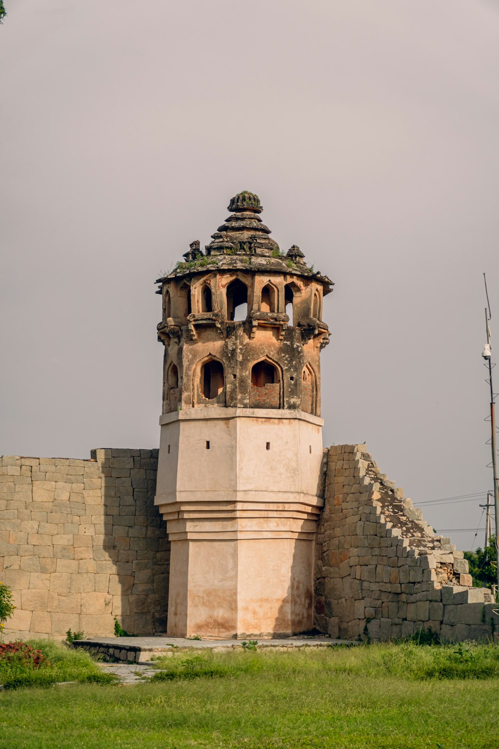 a tall tower sitting on top of a lush green field