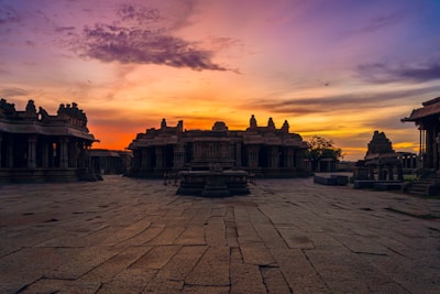 A serene temple courtyard filled with pilgrims during sunset.
