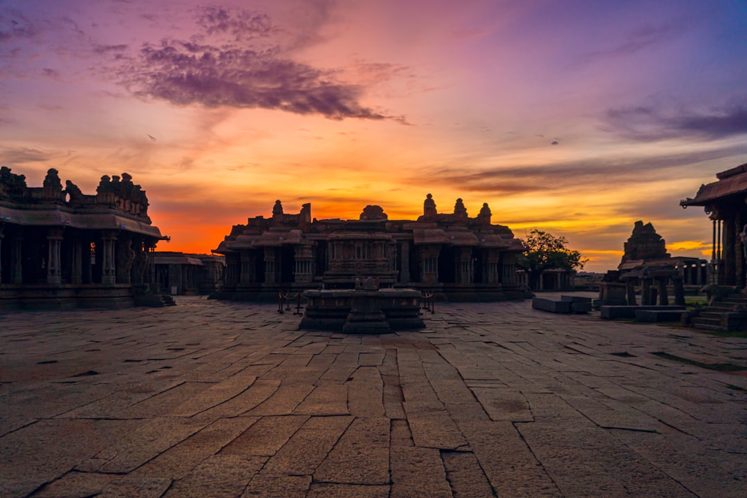the sun is setting over a large building,