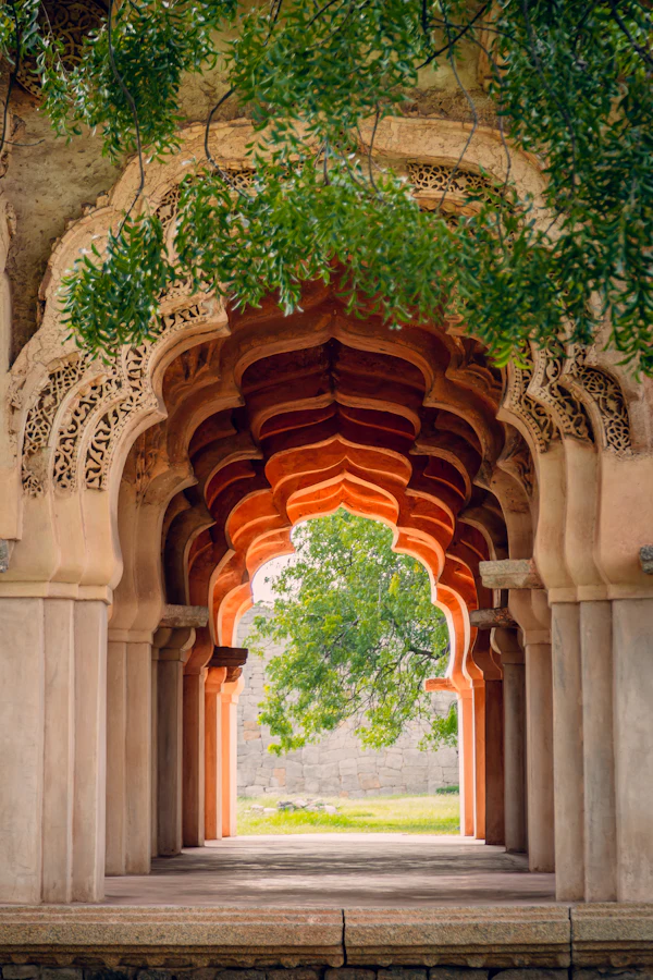 A stone archway at Hampi with a tree growing beside it