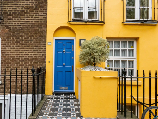 A finished home improvement project featuring a bright yellow door and matching trim.