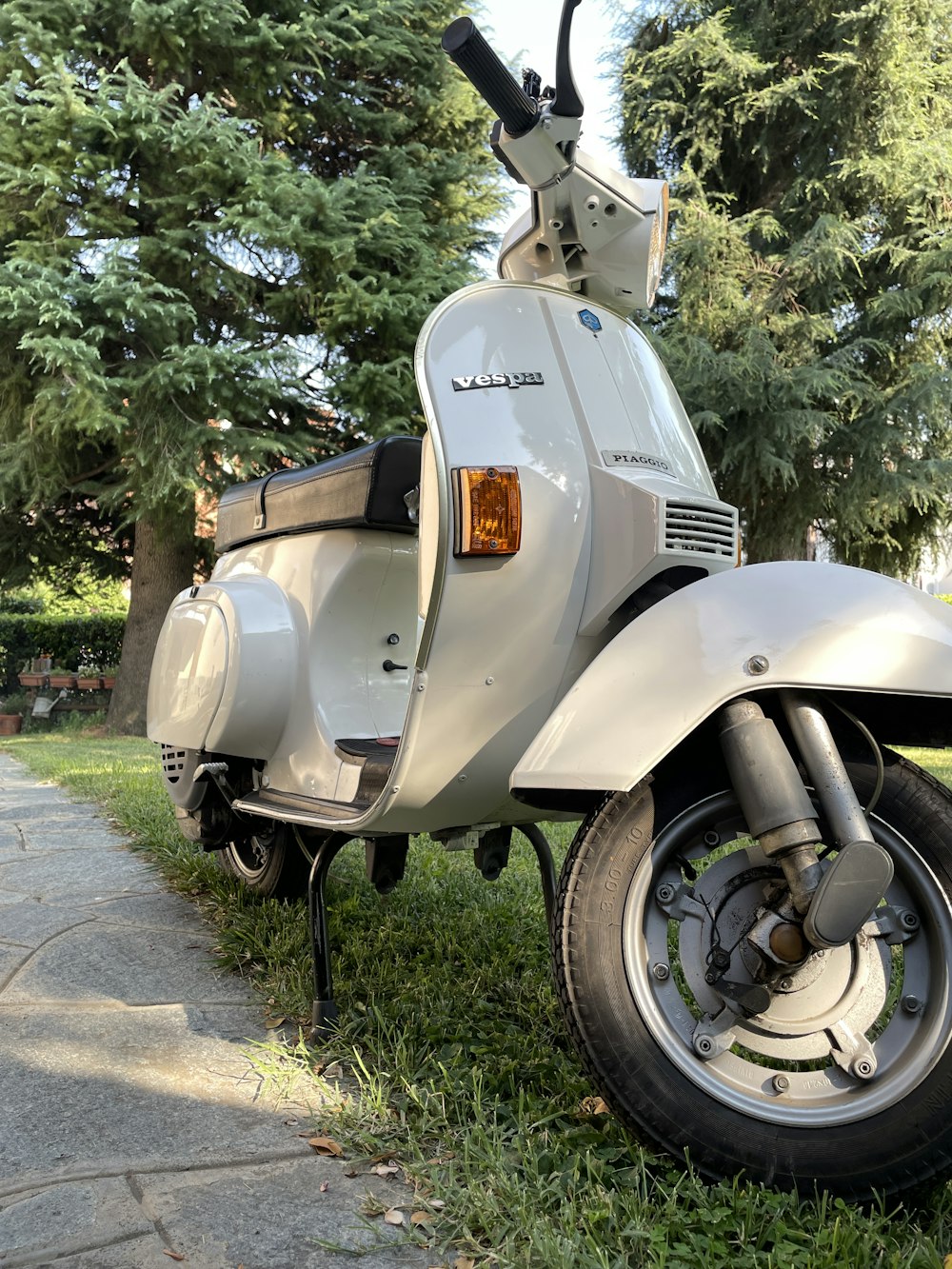 a white scooter parked on the side of a road