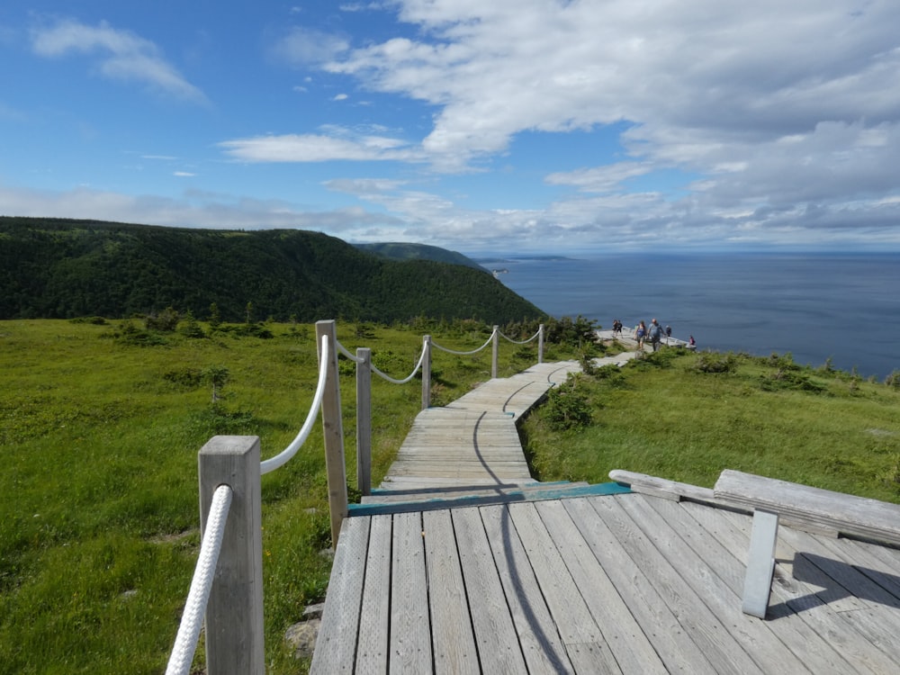 a wooden walkway leading to the ocean on a cloudy day