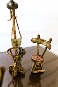 a wooden table topped with two metal chairs
