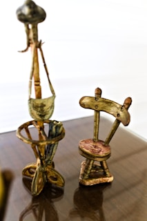 a wooden table topped with two metal chairs