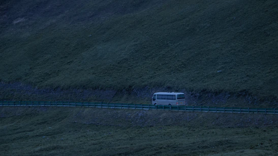 A modern bus speeding along a scenic highway at sunset in northern Mexico.
