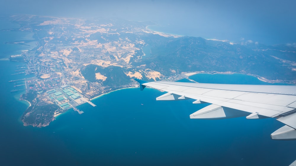 un ala de avión volando sobre una gran masa de agua