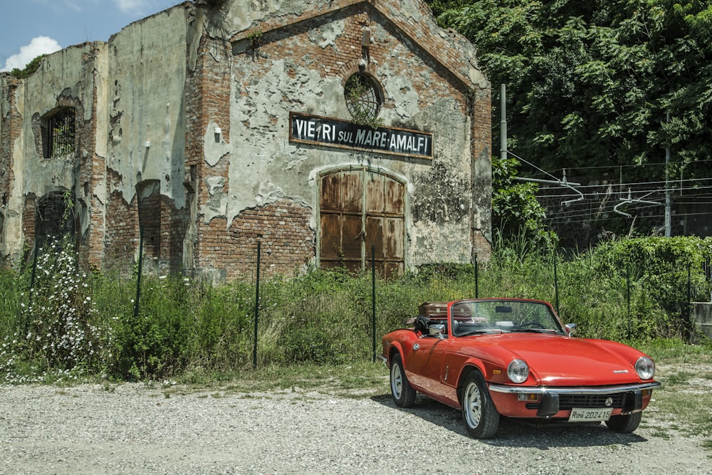 a red car parked in front of an old building