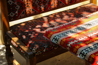 A vibrant handblock-printed t-shirt draped over a rustic wooden chair, bathed in warm natural light.