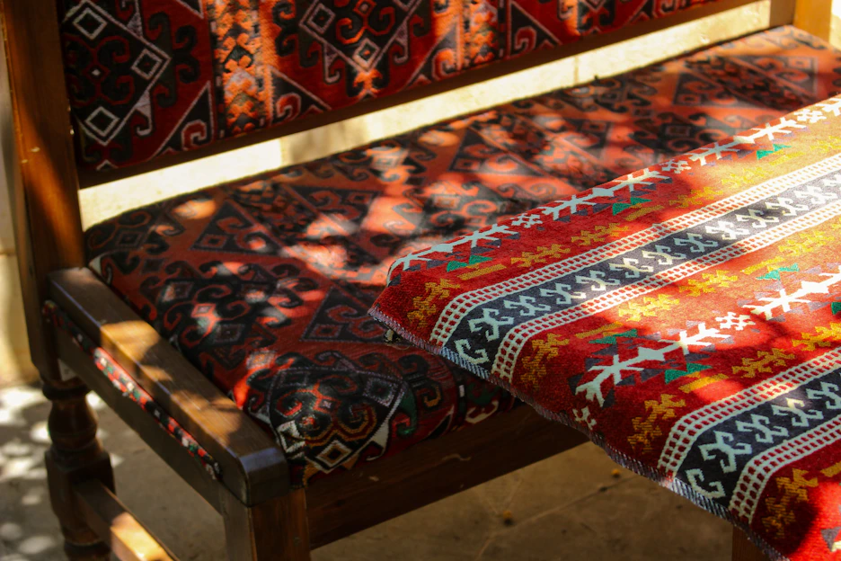 A vibrant handblock-printed t-shirt draped over a rustic wooden chair, bathed in warm natural light.
