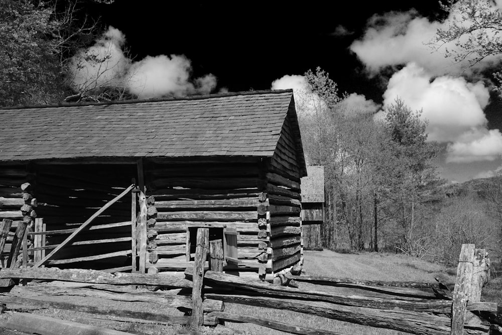 une photo en noir et blanc d’une cabane en rondins