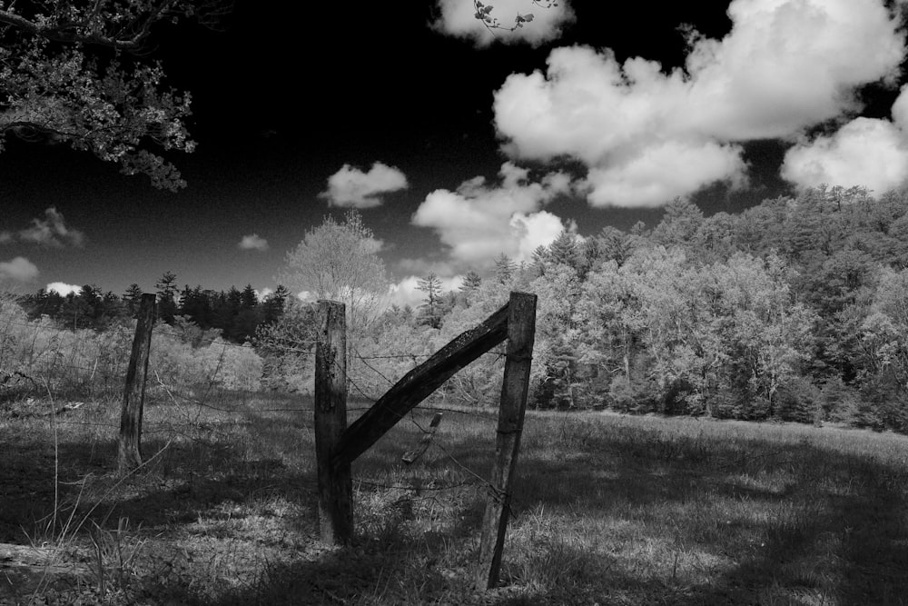 a black and white photo of a fence in a field