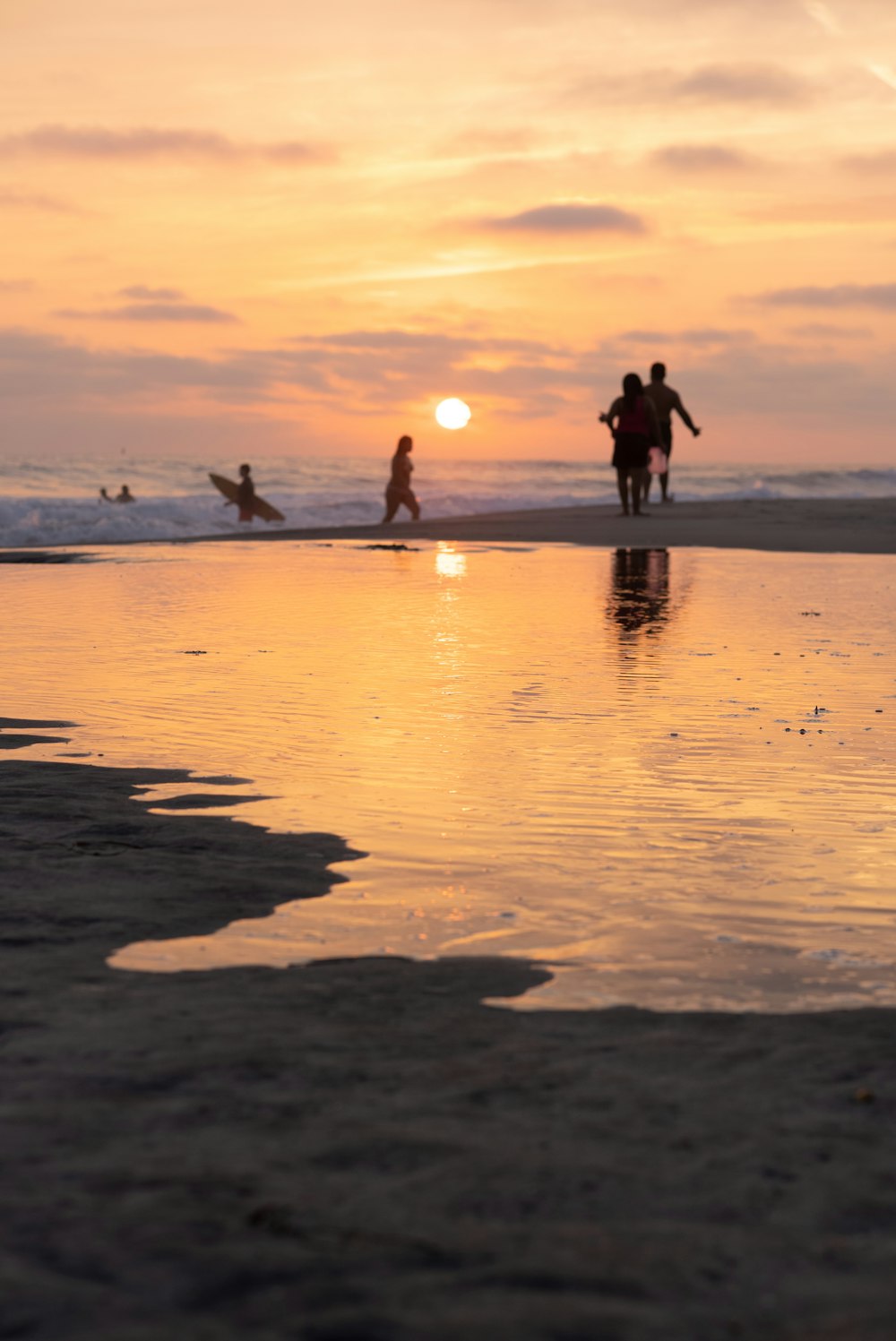 a group of people standing on top of a sandy beach