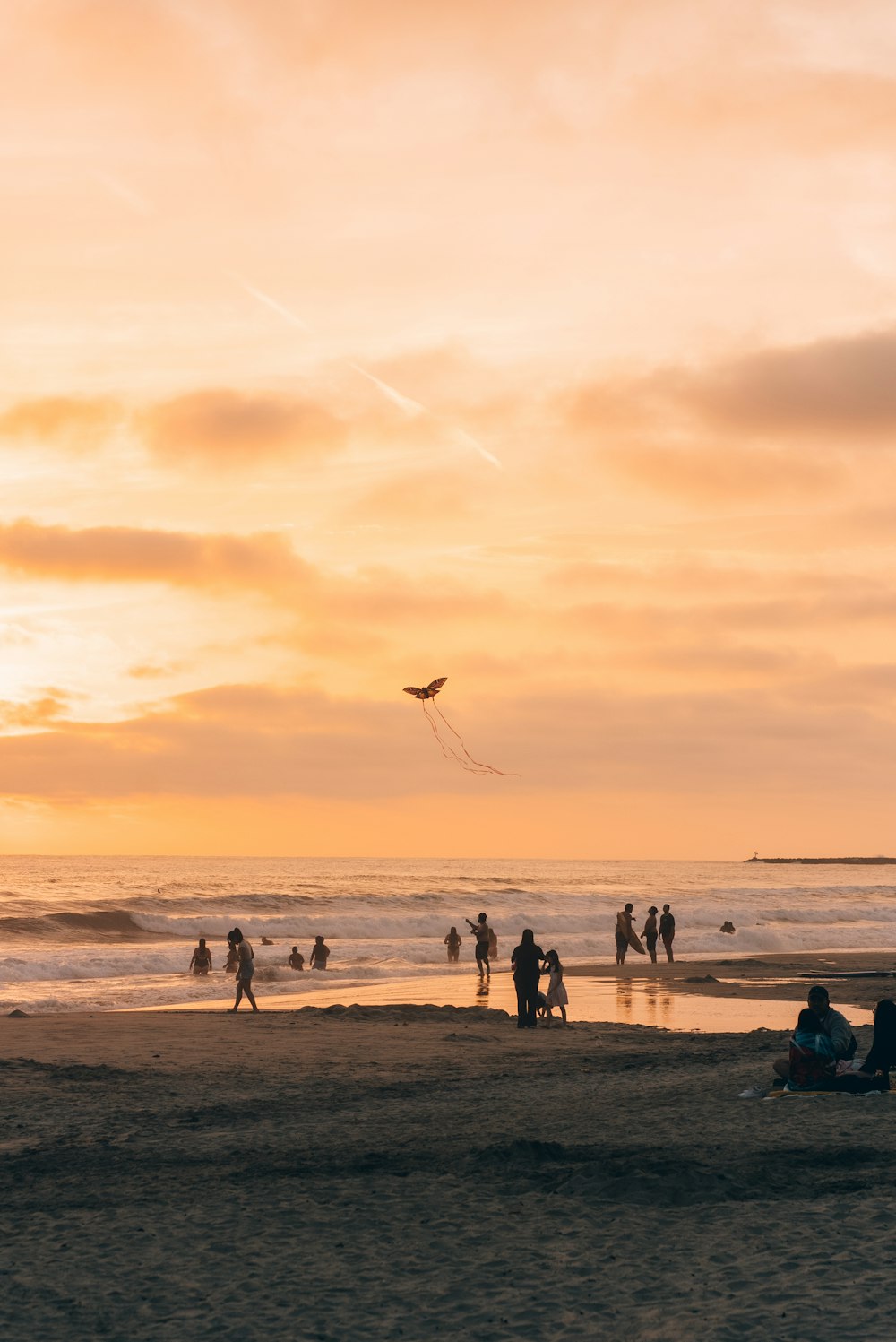 a group of people standing on top of a sandy beach