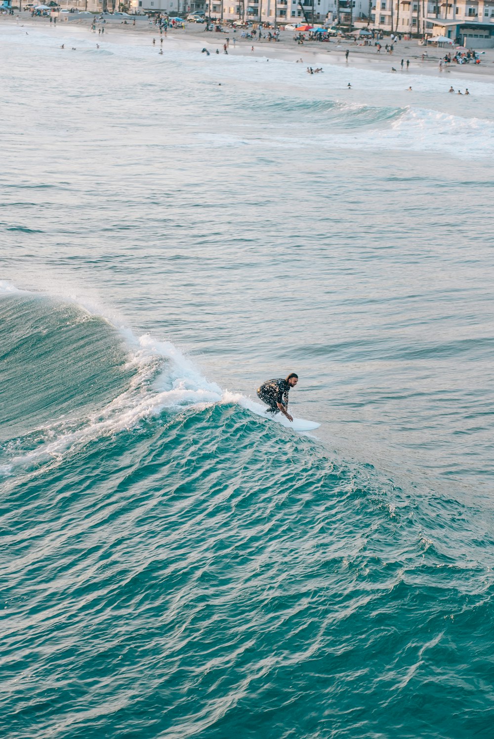 a man riding a wave on top of a surfboard