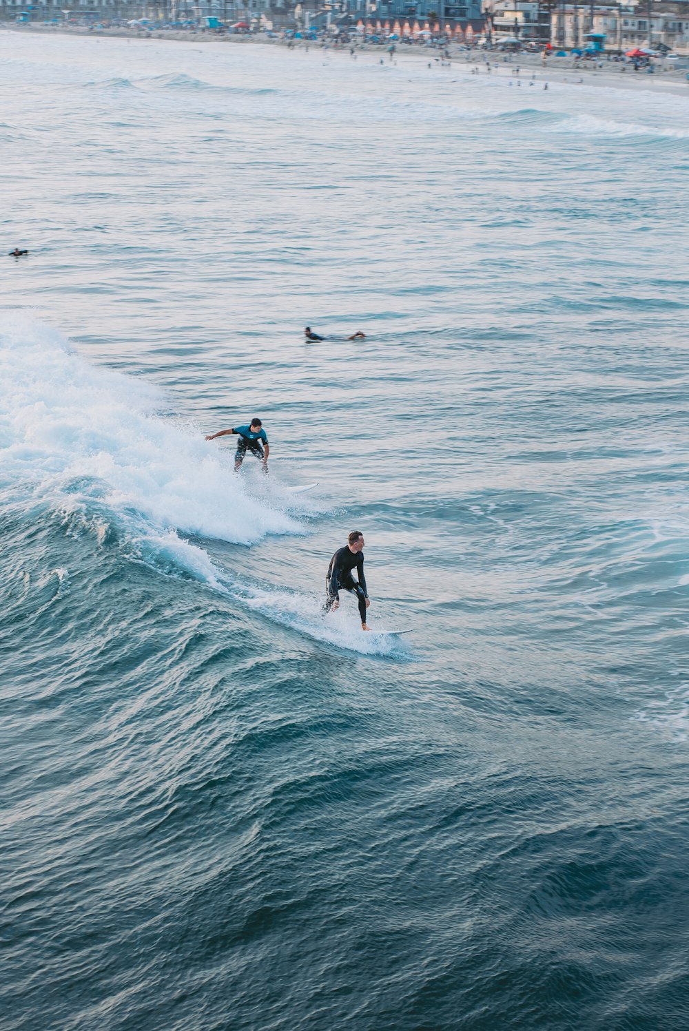 a group of people riding waves on top of surfboards