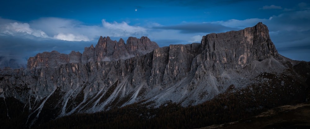 a very tall mountain with a moon in the sky