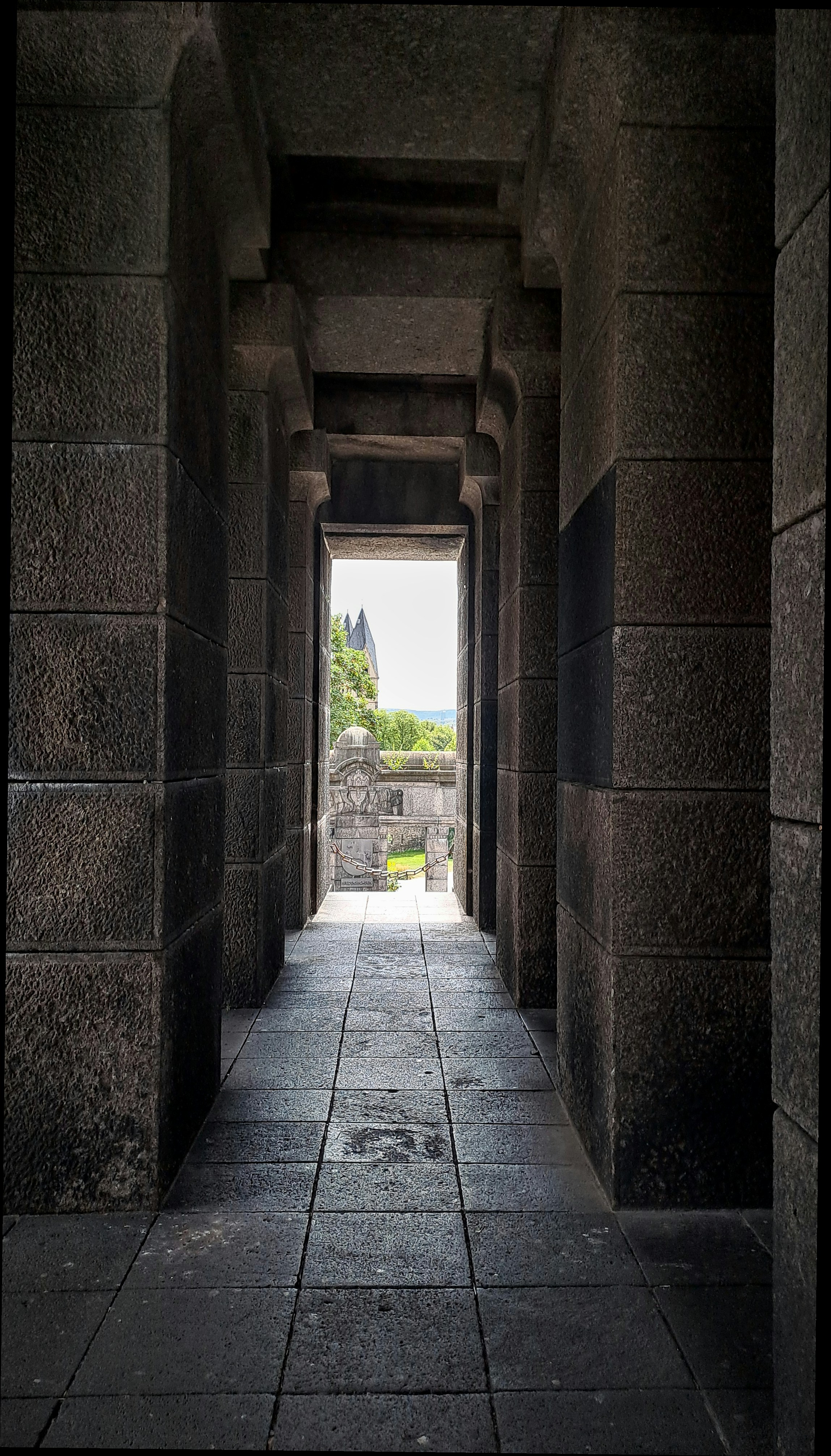 a long hallway with a view of a castle in the distance