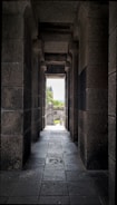 a long hallway with a view of a castle in the distance