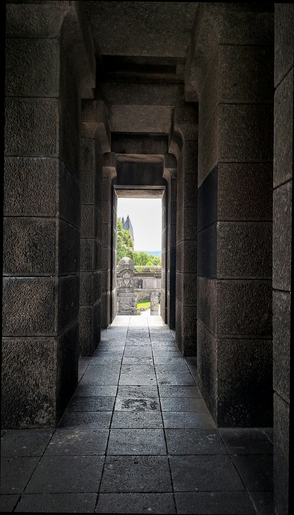 a long hallway with a view of a castle in the distance