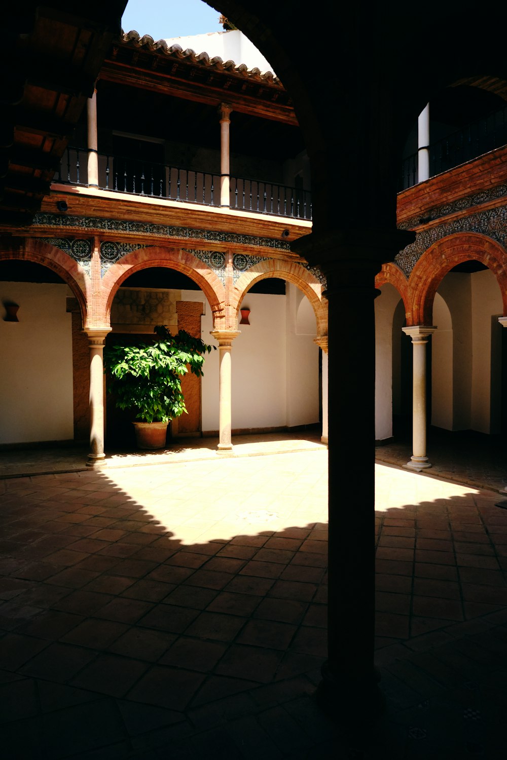 a courtyard with arches and a potted plant