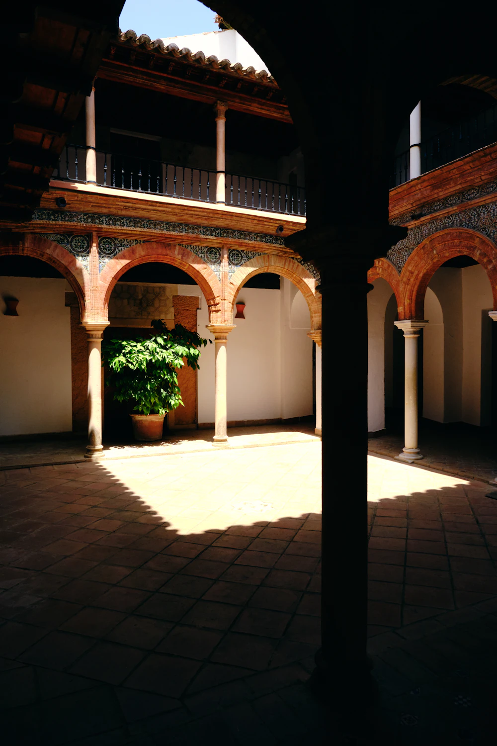 A courtyard with arches and a potted plant