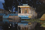 Evening view of the houseboat gently floating on Dal Lake with lights glowing softly.