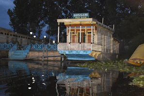 Evening view of the houseboat gently floating on Dal Lake with lights glowing softly.