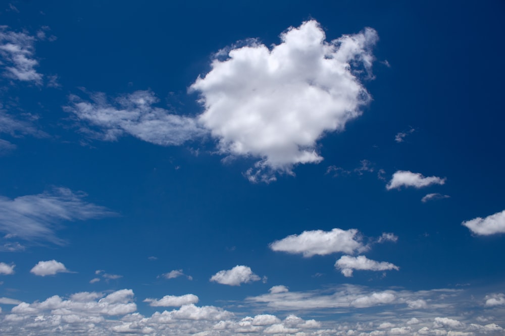 a large white cloud floating in a blue sky