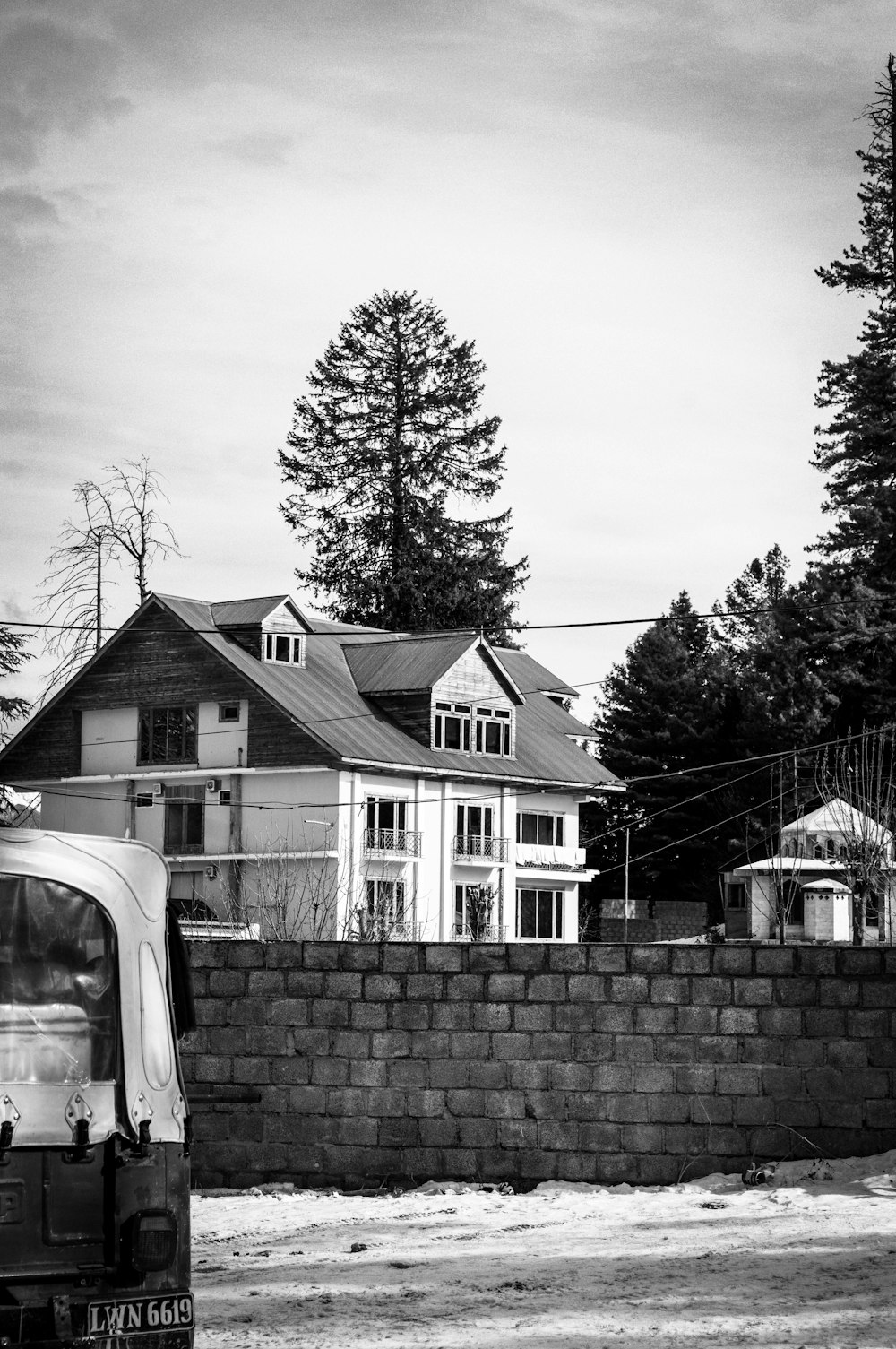 a black and white photo of a truck parked in front of a house