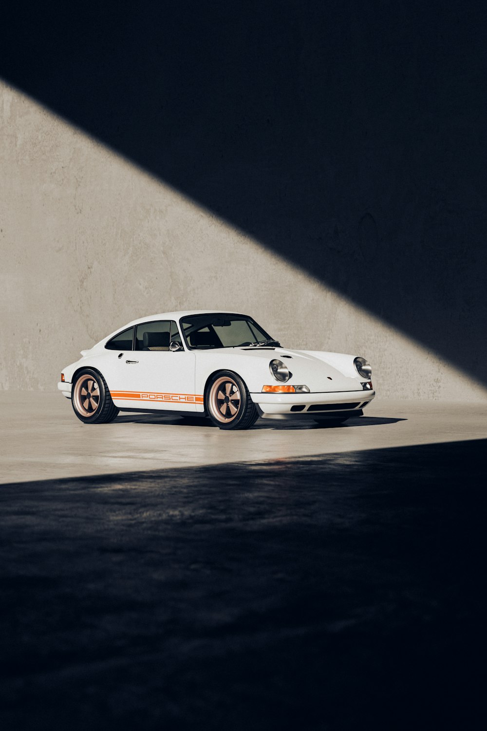 a white car parked in a parking lot next to a wall