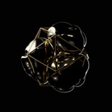 Abstract gold and black geometric shapes with light effects.