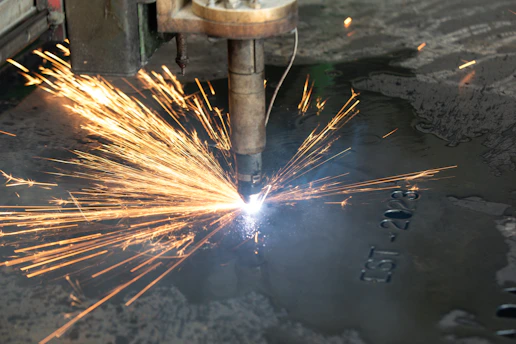 a welder cutting a piece of metal with sparks