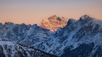 A serene sunrise casting golden light over the snow-capped peaks of the Swiss Alps.