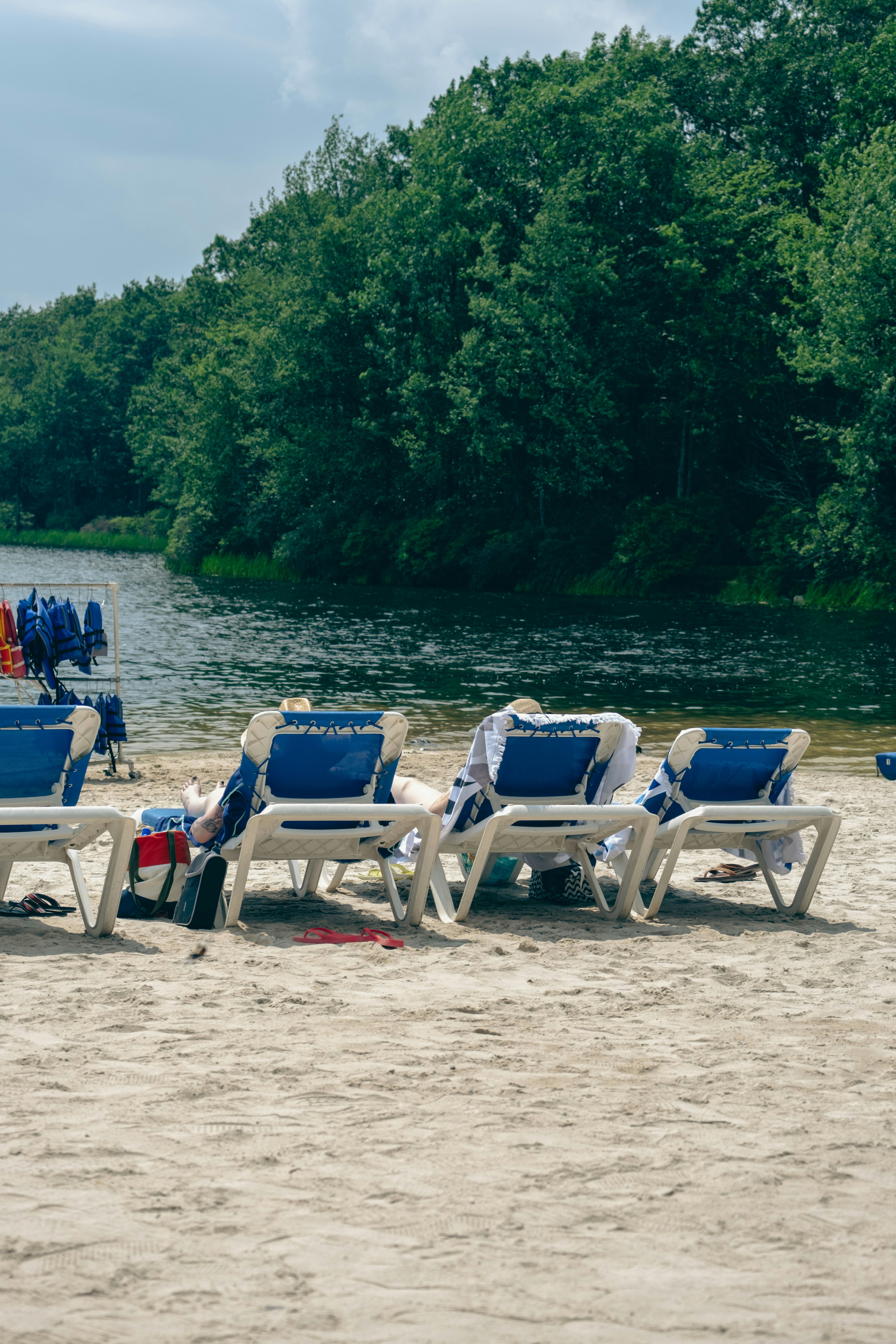 A row of lawn chairs sitting on top of a sandy beach photo – Free ...