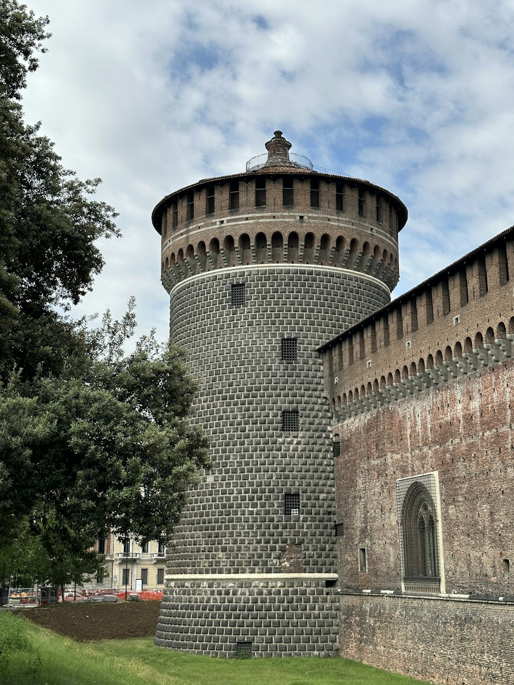 a very tall brick tower with a clock on it's side