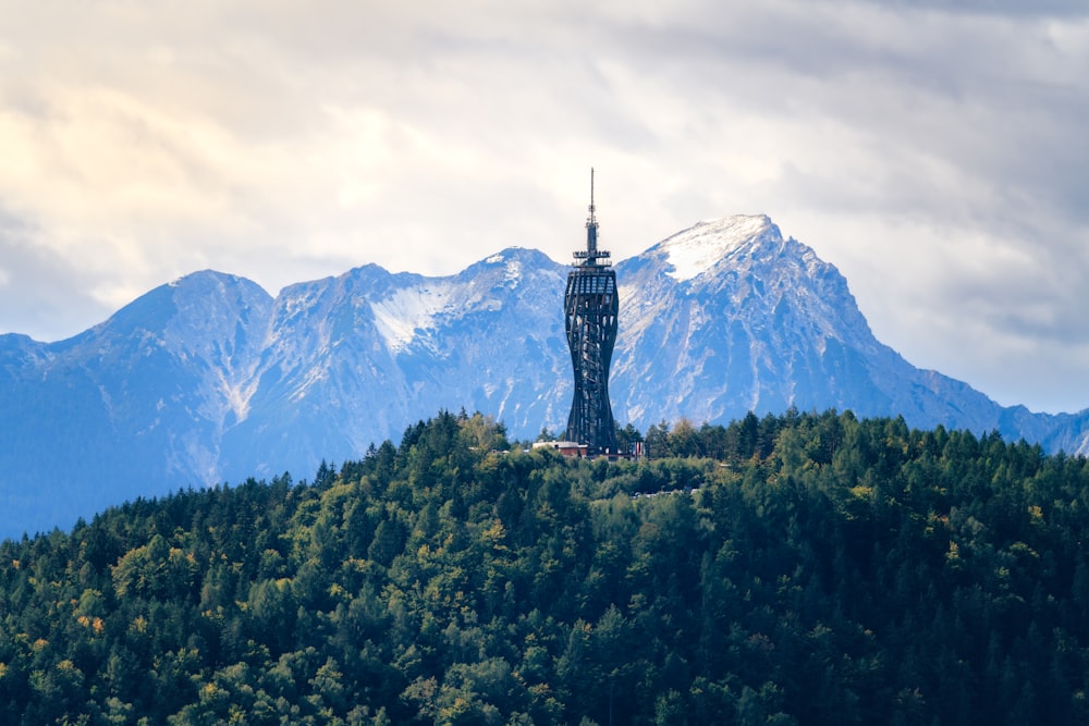 una torre alta sentada en la cima de una exuberante ladera verde