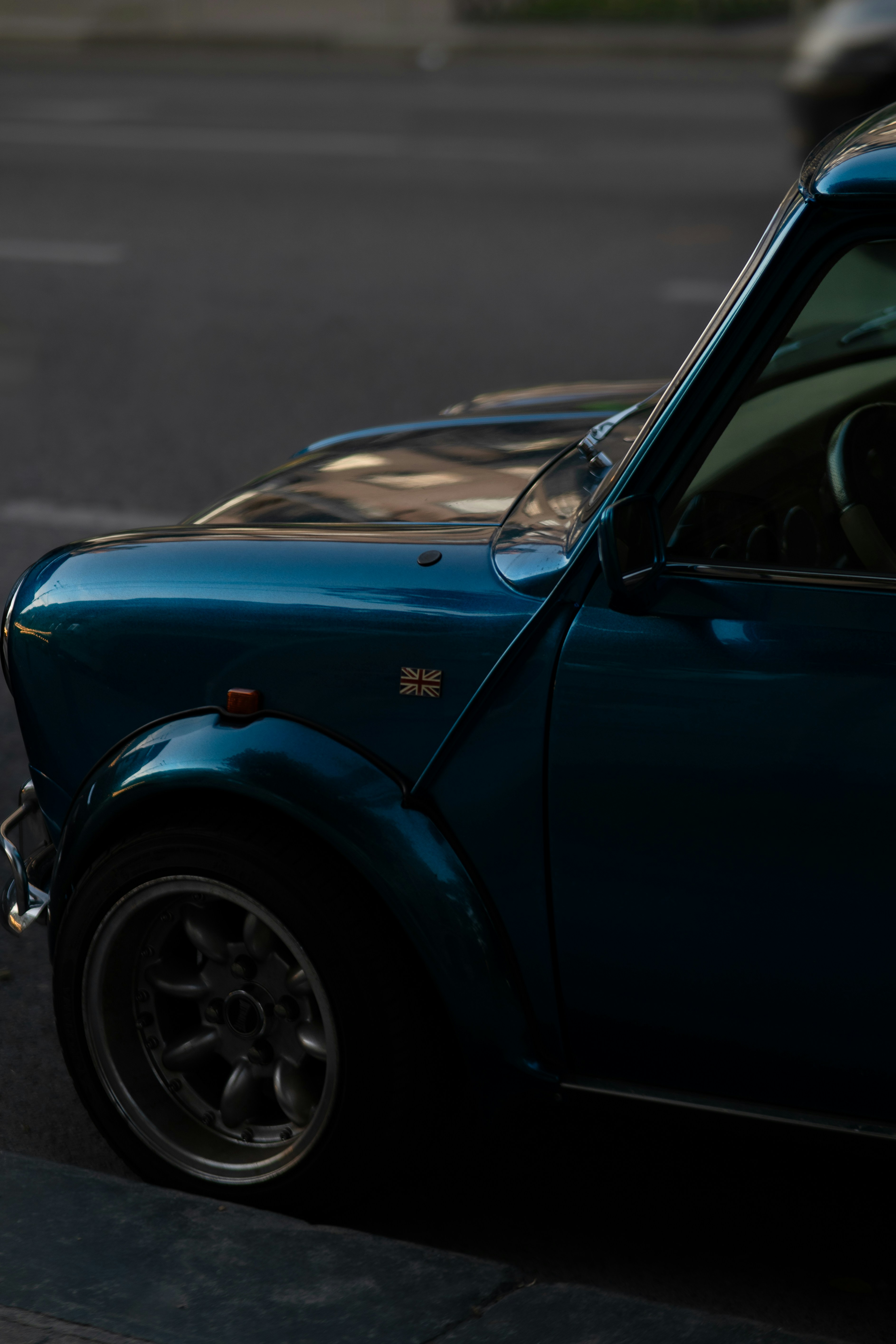 Un pequeño coche azul aparcado al costado de la carretera