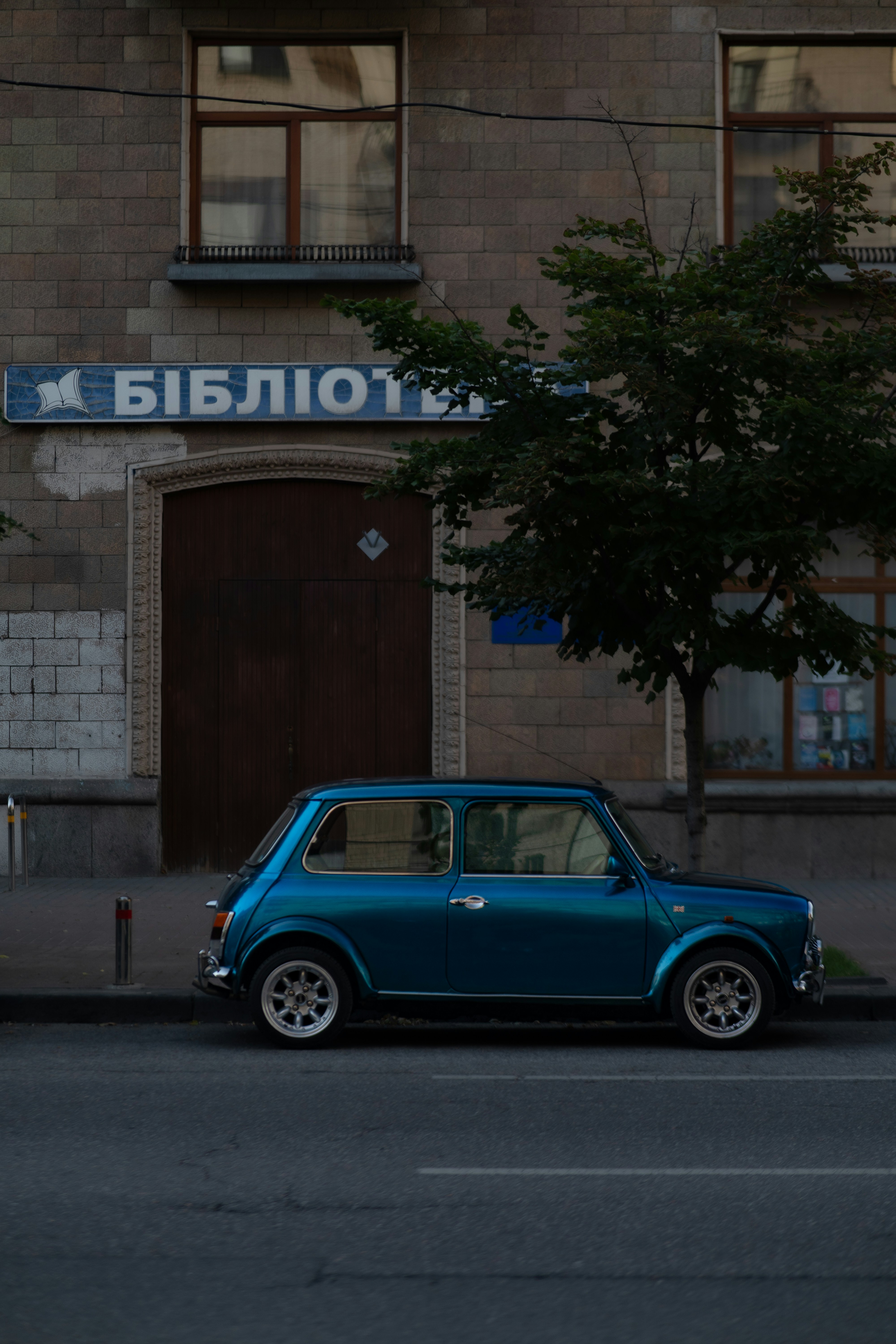 Un pequeño coche azul aparcado frente a un edificio