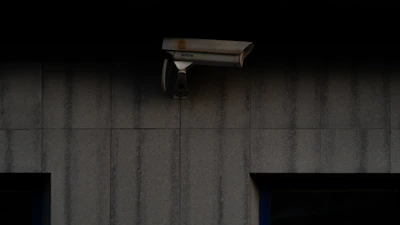 Close-up of security camera mounted on exterior wall at dusk