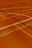 A floor is covered with intersecting lines of varying colors, including orange, blue, and dark brown. These lines form geometric shapes such as rectangles and curves, creating a visually striking pattern.