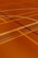 A floor is covered with intersecting lines of varying colors, including orange, blue, and dark brown. These lines form geometric shapes such as rectangles and curves, creating a visually striking pattern.